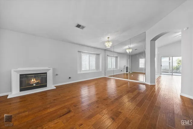 a view of empty room with wooden floor and fireplace