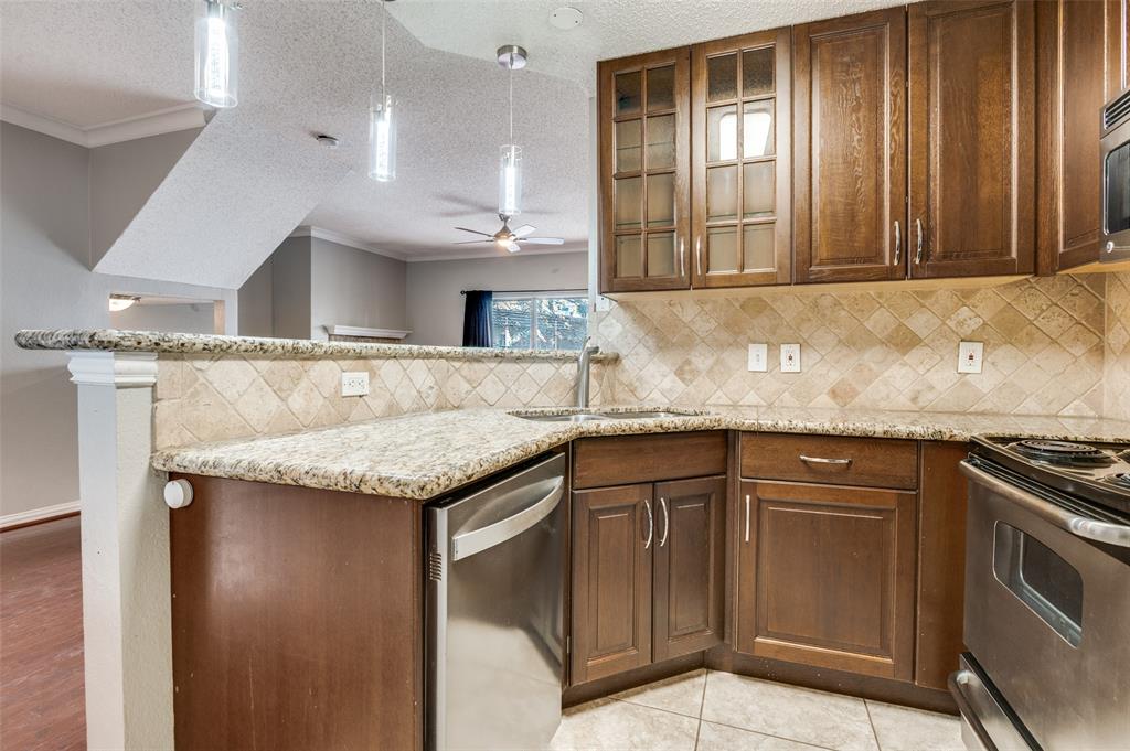 2201 Wolf Street, Unit 5107 Dallas, TX 75201 - Photo 10 of 21 a kitchen with granite countertop stainless steel appliances a sink stove and cabinets