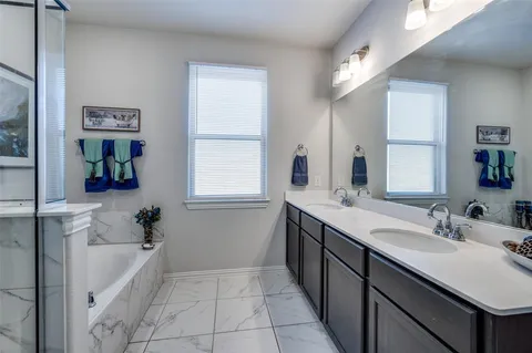 a bathroom with a tub sink and mirror