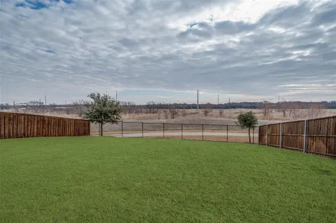 a view of a backyard with plants and lake view