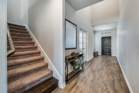 a view of a hallway with wooden floor and staircase