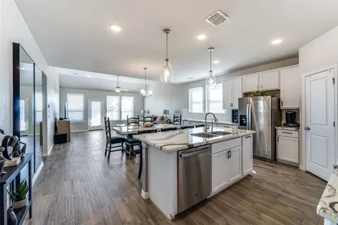 a kitchen with stainless steel appliances granite countertop a lot of counter space and wooden floors