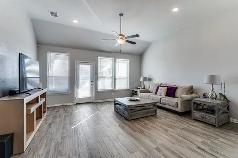 a living room with furniture flat screen tv and wooden floor