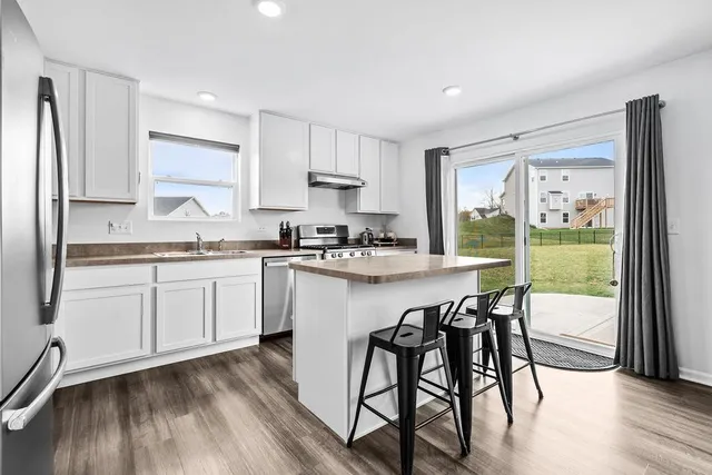 a living room with stainless steel appliances granite countertop furniture and a table