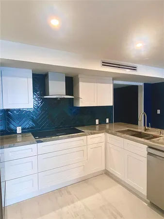 a kitchen with granite countertop white cabinets and sink