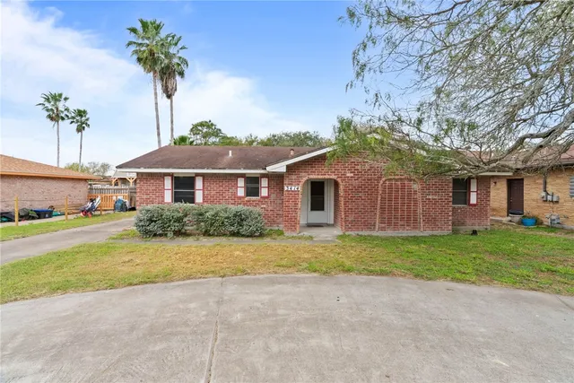 a front view of a house with a garden and yard