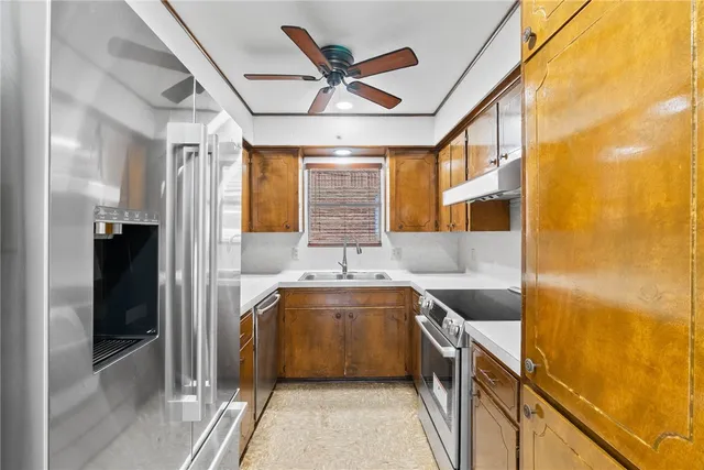 a kitchen with stainless steel appliances granite countertop a sink and a refrigerator
