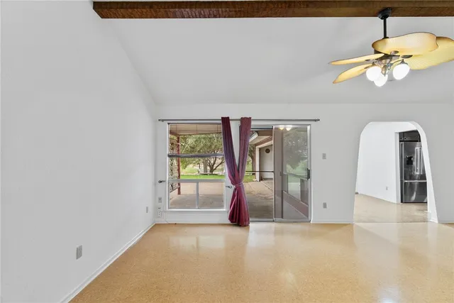 an empty room with windows and chandelier