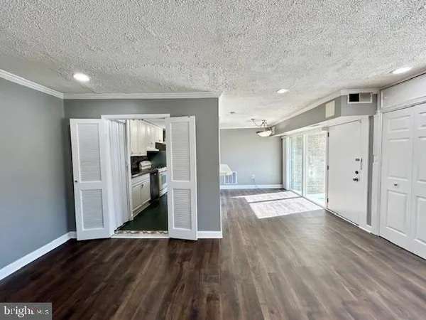 a view of a kitchen with wooden floor and a refrigerator