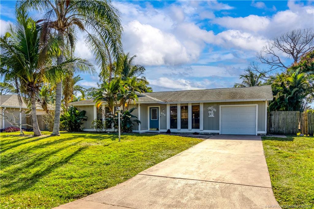 656 Southeast Ron Rico Terrace Port St. Lucie, FL 34983 - Photo 20 of 20 a view of a house with swimming pool and a yard