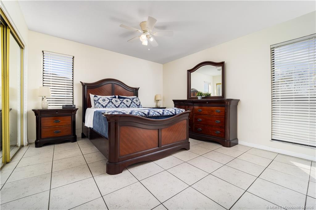 656 Southeast Ron Rico Terrace Port St. Lucie, FL 34983 - Photo 6 of 20 a spacious bedroom with a bed and a cabinets