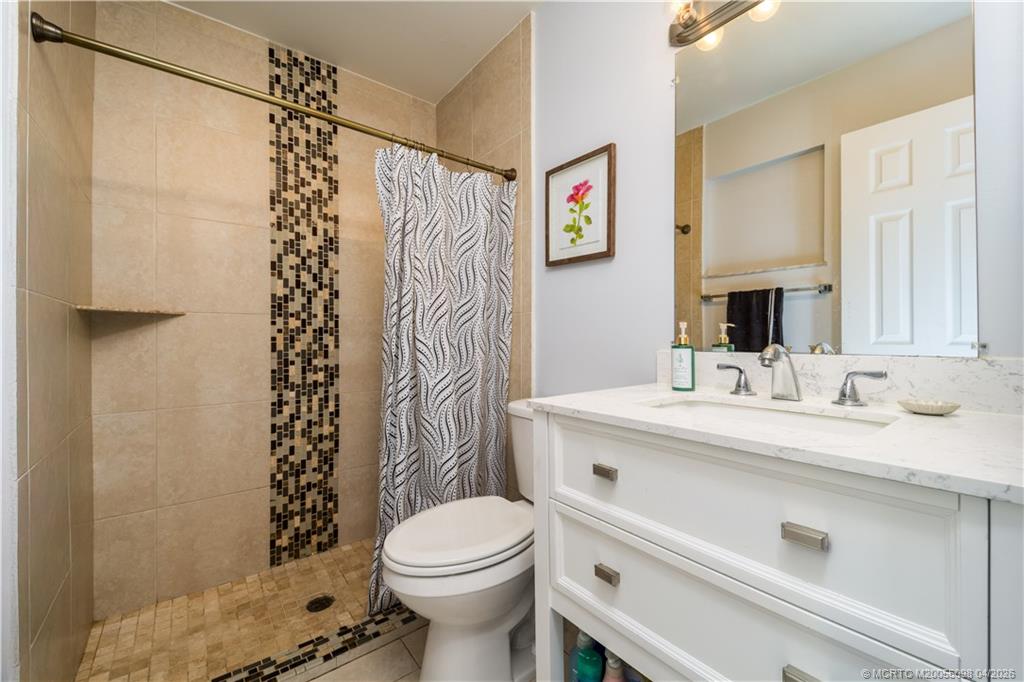 656 Southeast Ron Rico Terrace Port St. Lucie, FL 34983 - Photo 8 of 20 a bathroom with a sink a toilet and shower