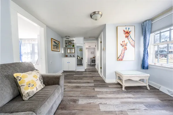 a living room with furniture and a painting on the wall