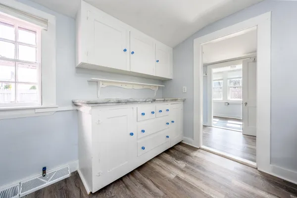 a kitchen with granite countertop a white stove and white cabinets