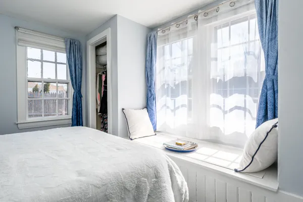 a bedroom with a bed and a large window