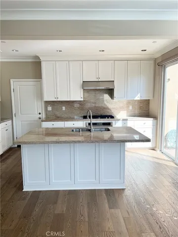 a kitchen with stainless steel appliances granite countertop a sink a stove a microwave and cabinets