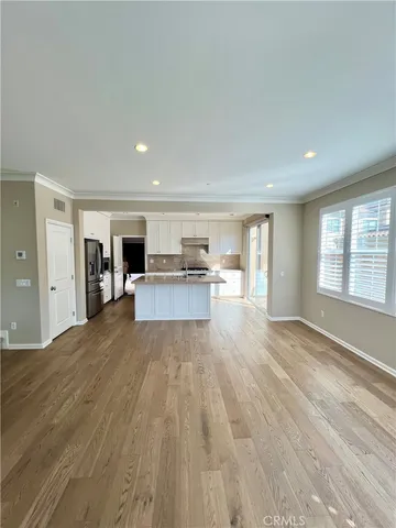 a big room with wooden floor and windows