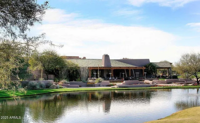 a front view of house with yard and trees in the background