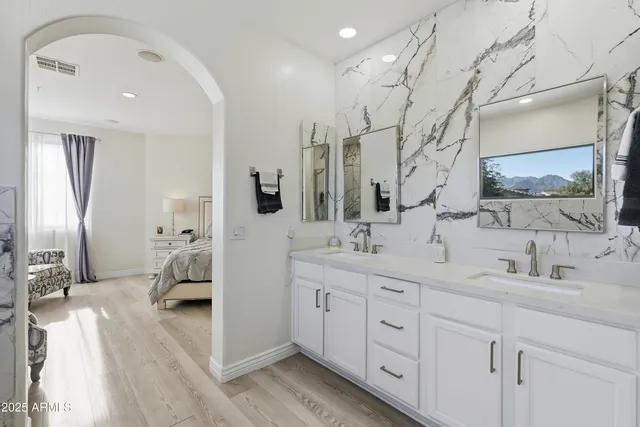 a bathroom with double sink and a mirror
