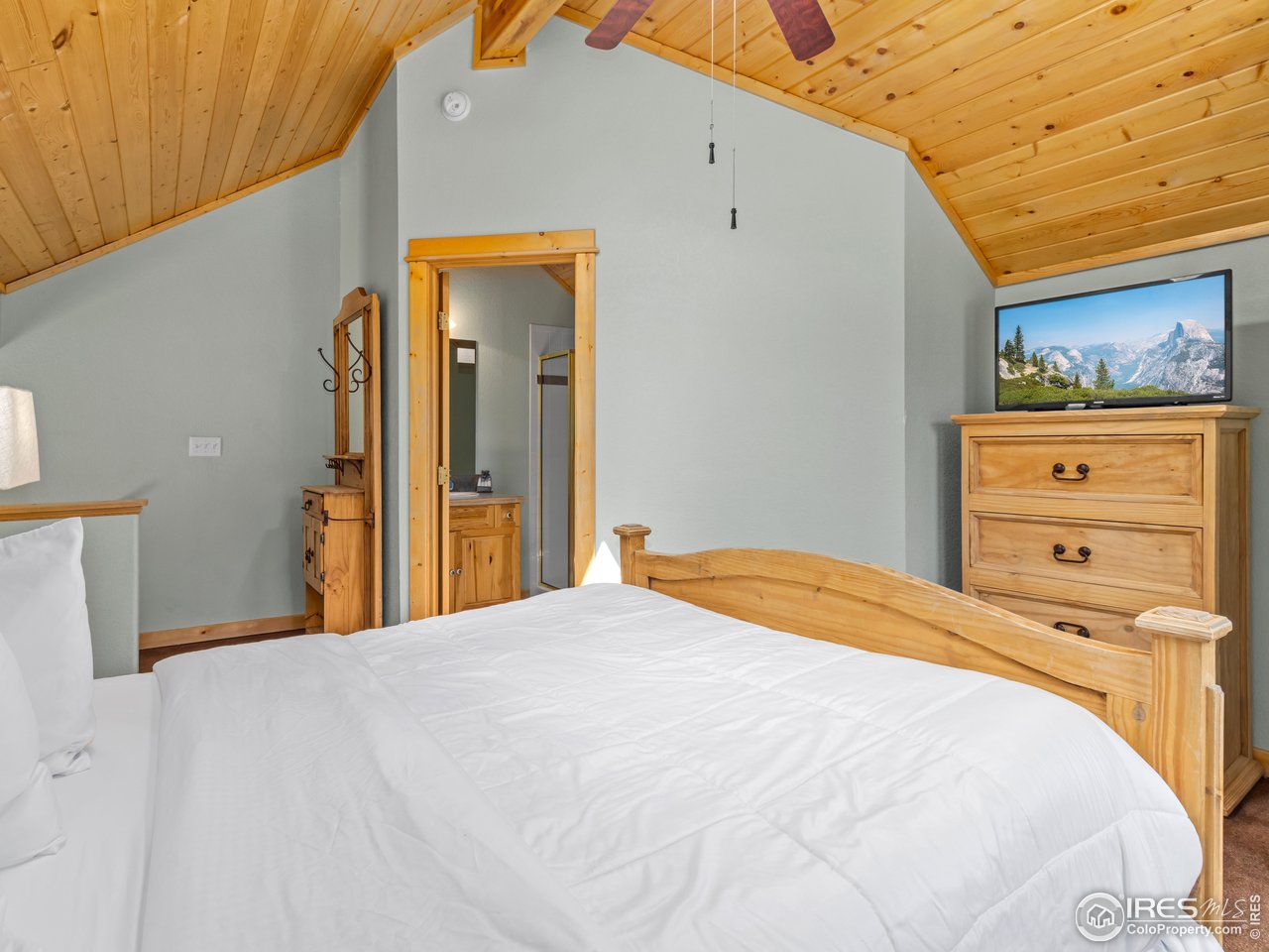 1340 Fall River Drive, Unit E Estes Park, CO 80517 - Photo 23 of 28 a bedroom with a bed and a painting on the wall