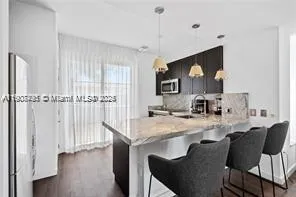 a kitchen with a table chairs refrigerator and cabinets