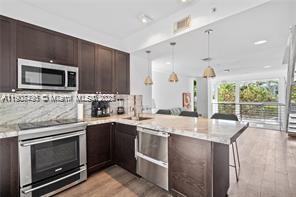 1600 Michigan Avenue, Unit 7 Miami Beach, FL 33139 - Photo 3 of 28 a kitchen with a stove and a microwave