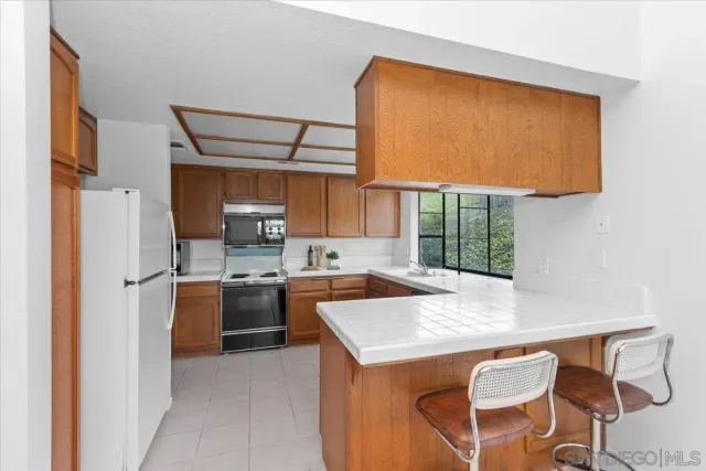 a kitchen with a refrigerator a stove and a sink