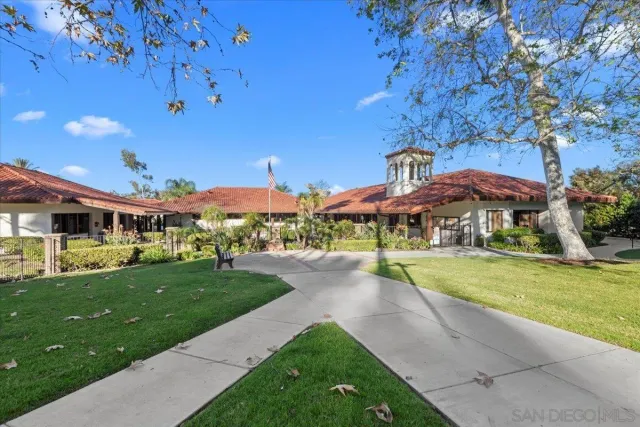 a view of a big house with a big yard and potted plants