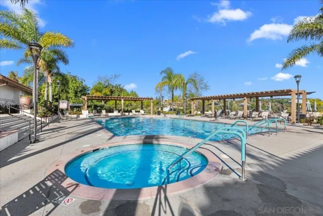 a view of a swimming pool with a patio and a yard