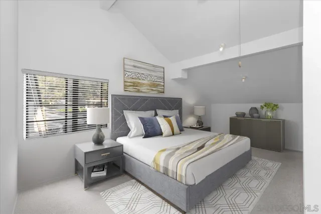 a bedroom with a bed table chair and a window