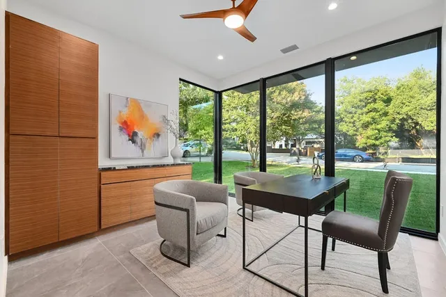 a dining room with furniture a flat screen tv and a floor to ceiling window