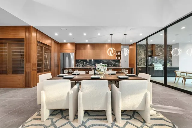 a kitchen with a dining table chairs stainless steel appliances and cabinets