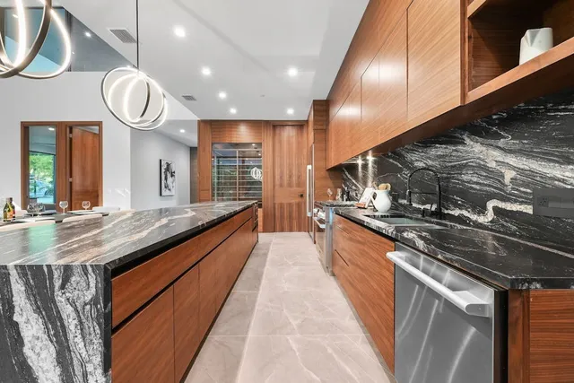 a large kitchen with stainless steel appliances granite countertop a stove and a sink