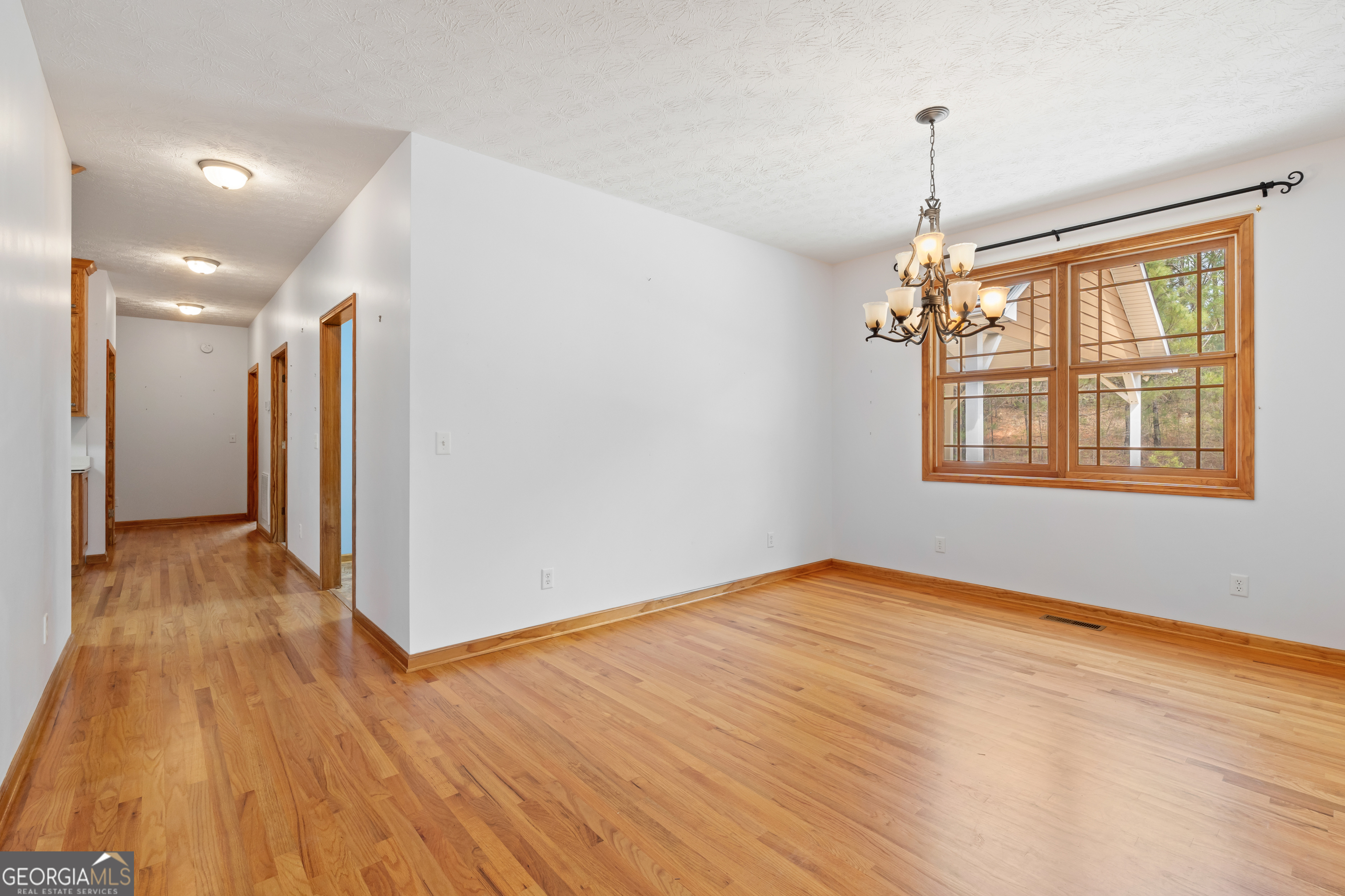 1229 Boggus Road Franklin, GA 30217 - Photo 13 of 68 a view of an empty room with wooden floor and a window