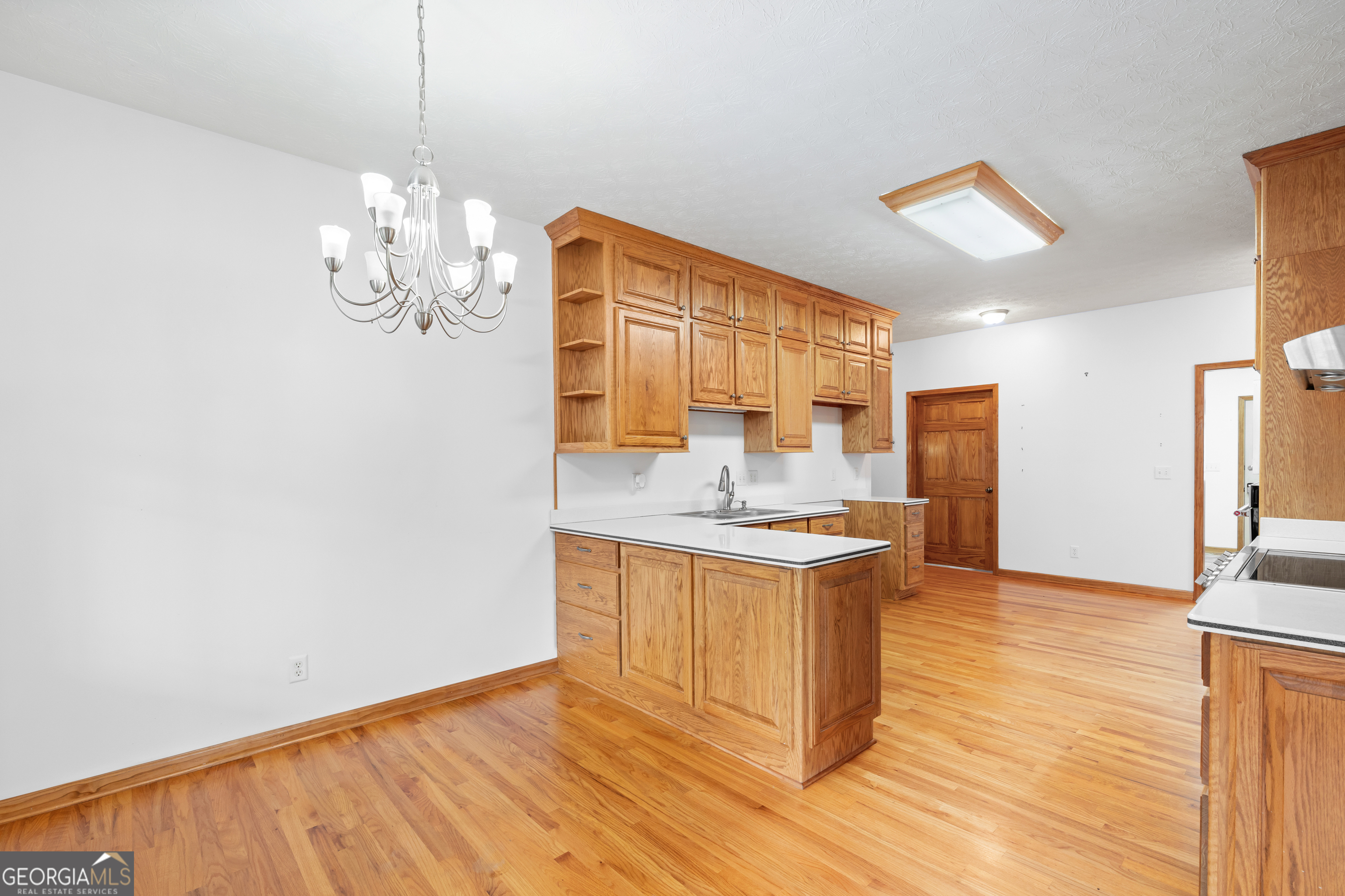 1229 Boggus Road Franklin, GA 30217 - Photo 16 of 68 a kitchen with stainless steel appliances granite countertop a sink cabinets and wooden floor