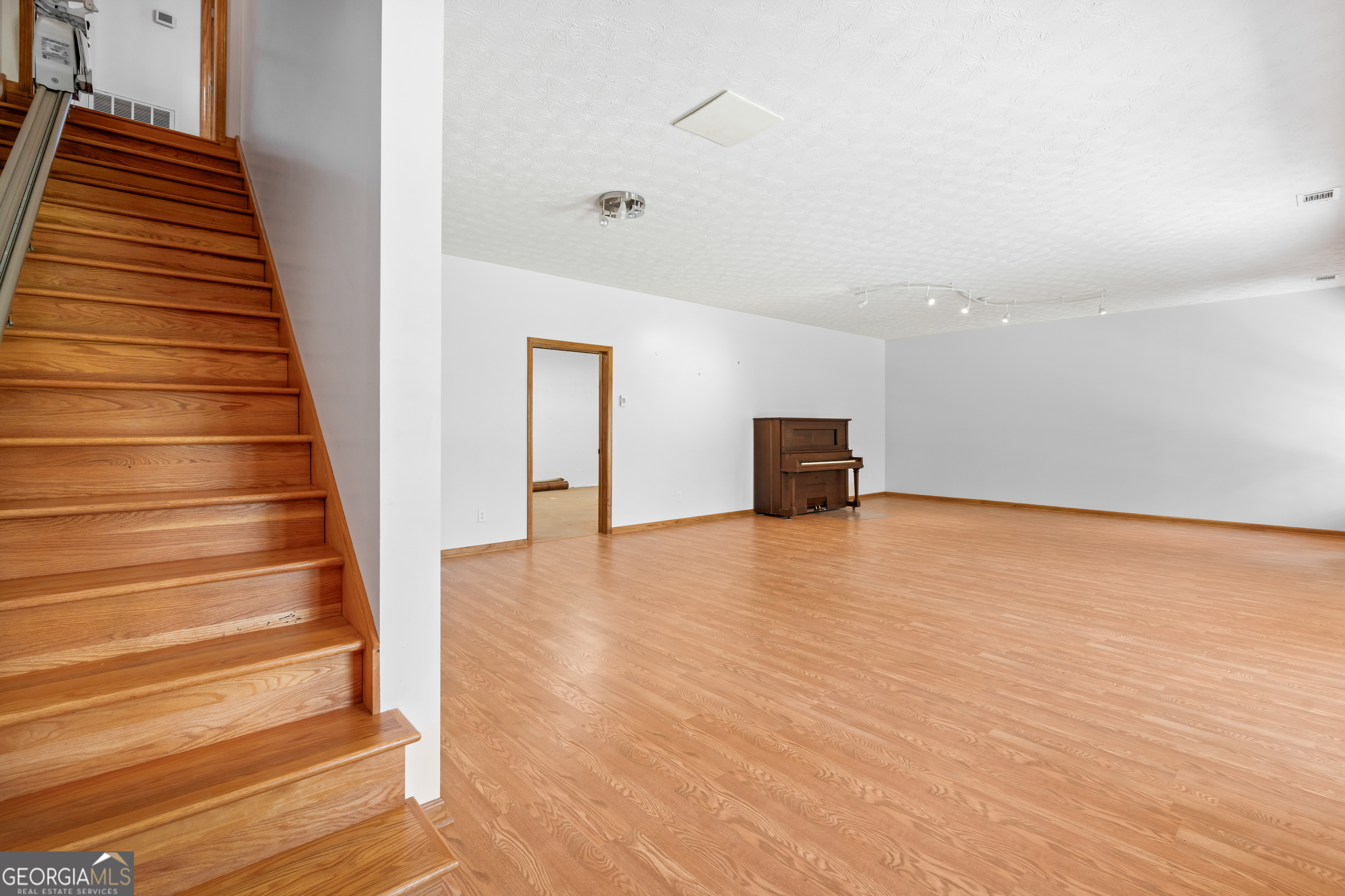 1229 Boggus Road Franklin, GA 30217 - Photo 33 of 68 a view of an empty room with wooden floor and stairs