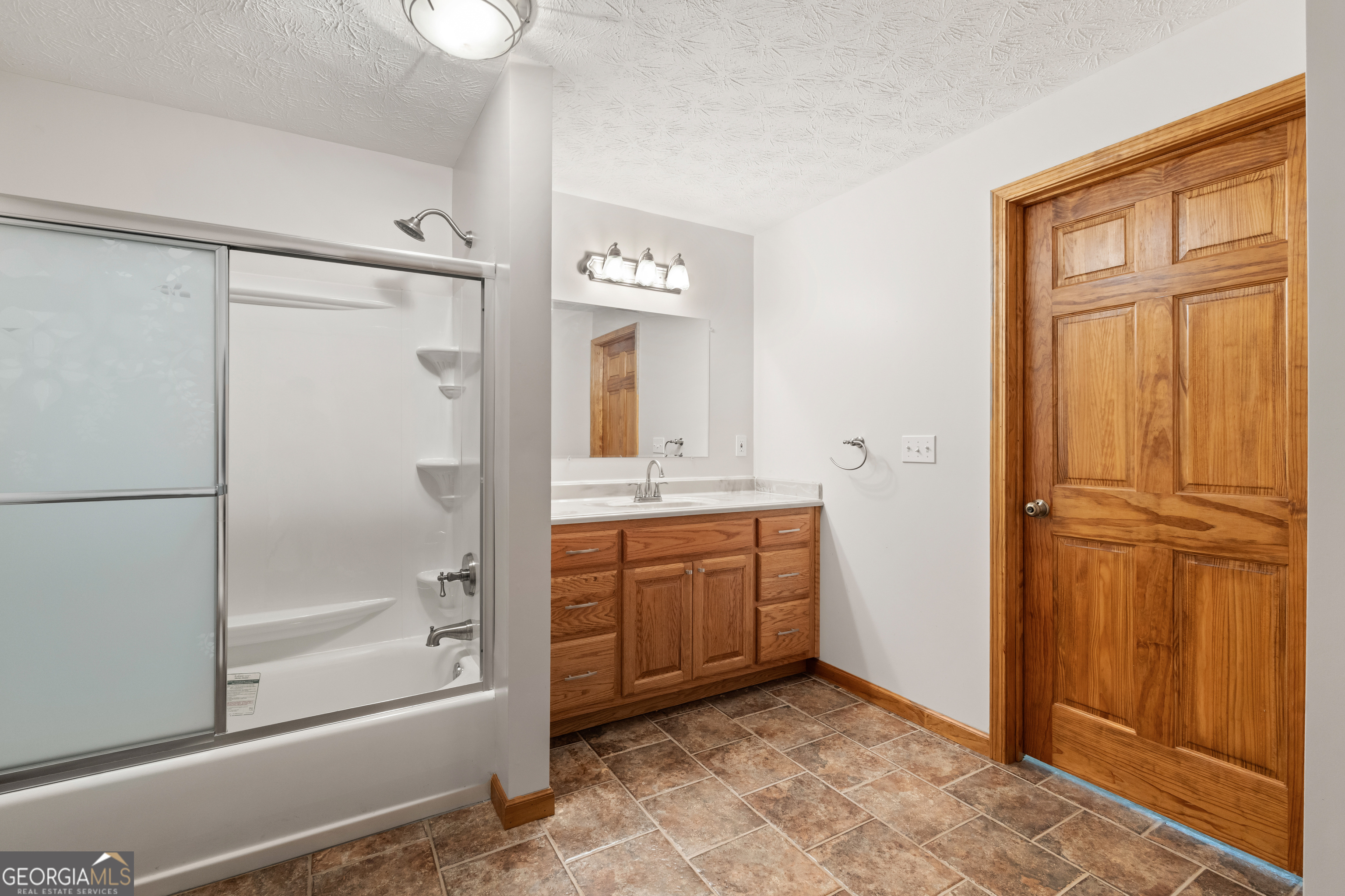 1229 Boggus Road Franklin, GA 30217 - Photo 39 of 68 a bathroom with a granite countertop sink mirror and a bathtub