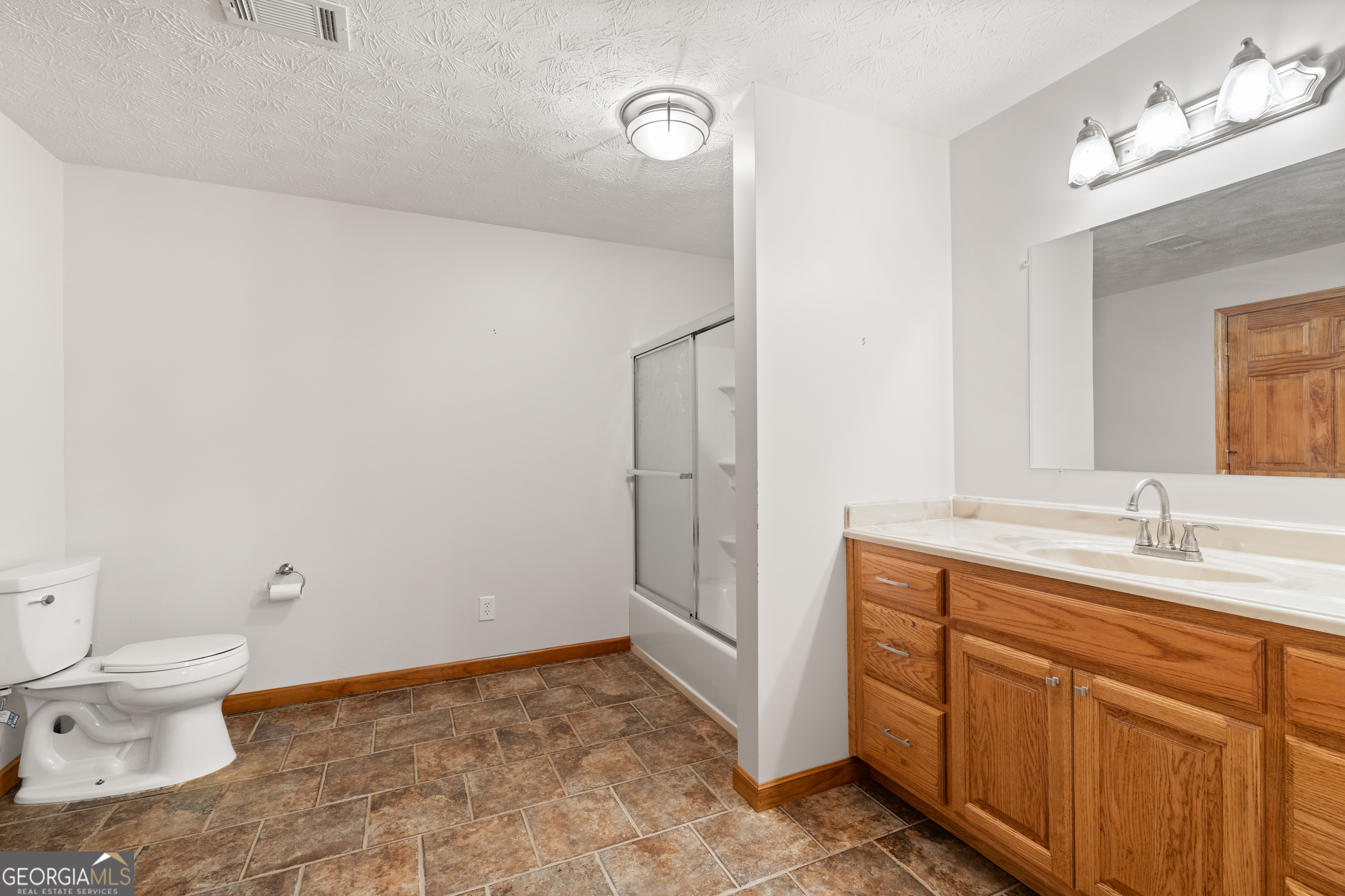 1229 Boggus Road Franklin, GA 30217 - Photo 40 of 68 a bathroom with a granite countertop sink a toilet and a mirror