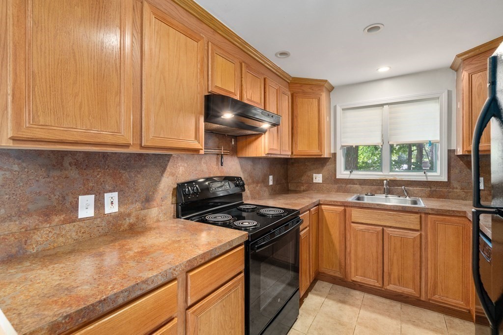 21 Fayette Street Watertown, MA 02472 - Photo 14 of 25 a kitchen with stainless steel appliances granite countertop a sink stove and cabinets