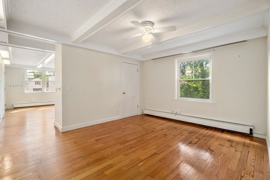 21 Fayette Street Watertown, MA 02472 - Photo 15 of 25 wooden floor in an empty room with a window
