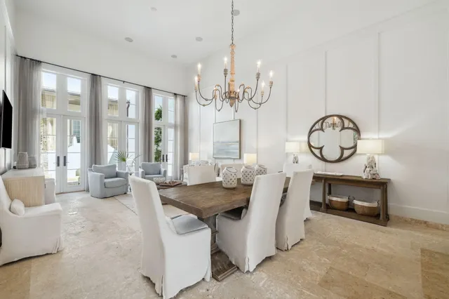 a view of a dining room with furniture a chandelier and a large window