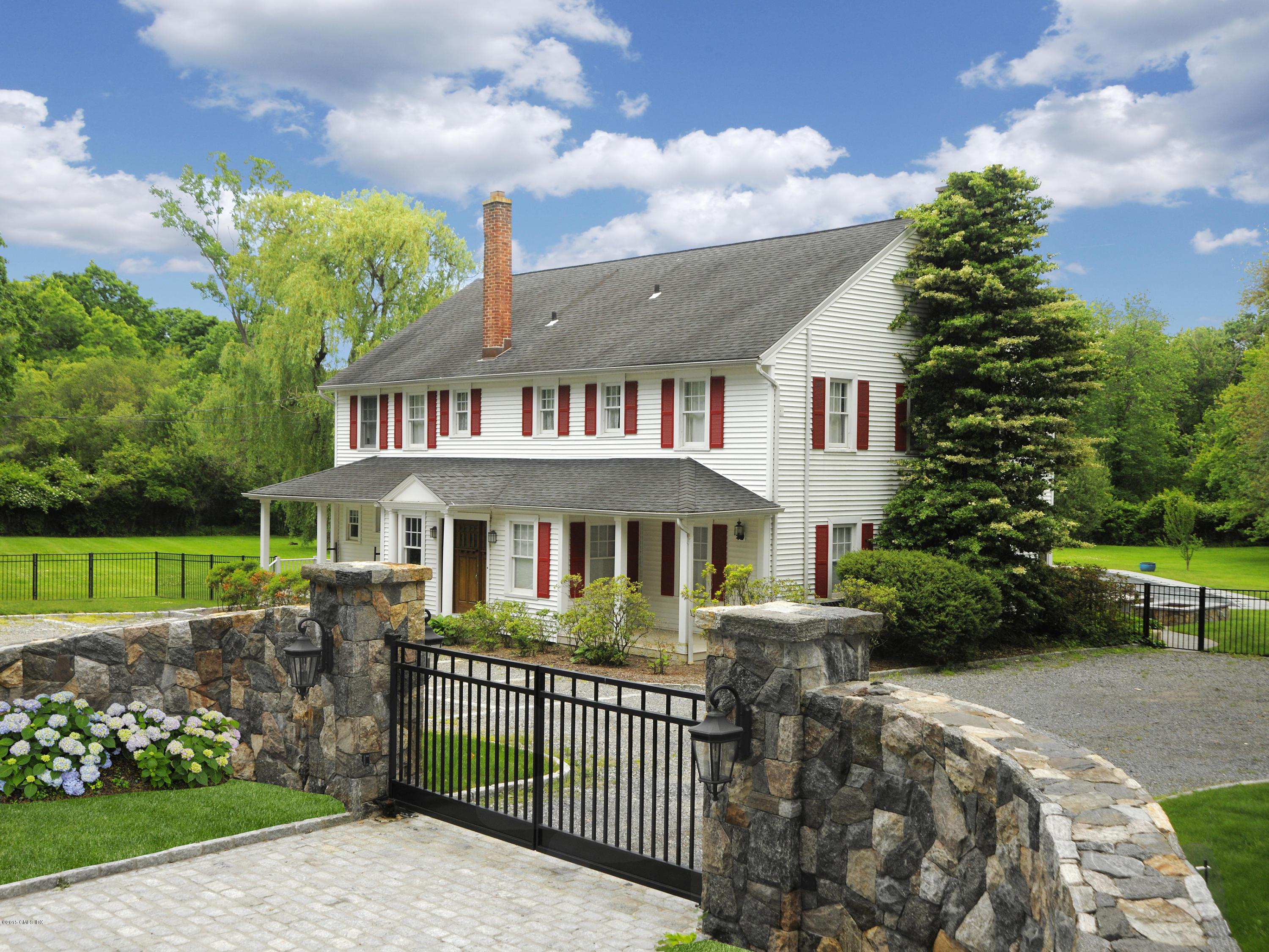 48 Locust Road Greenwich, CT 06831 - Photo 1 of 20 a front view of a house with a garden