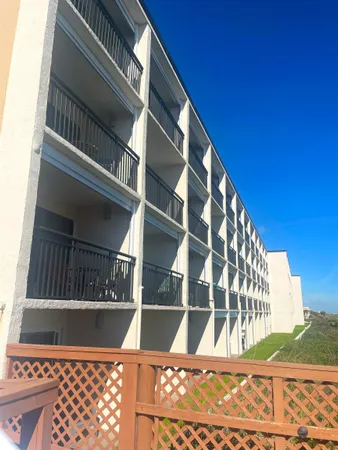 a view of balcony with wooden floor and fence
