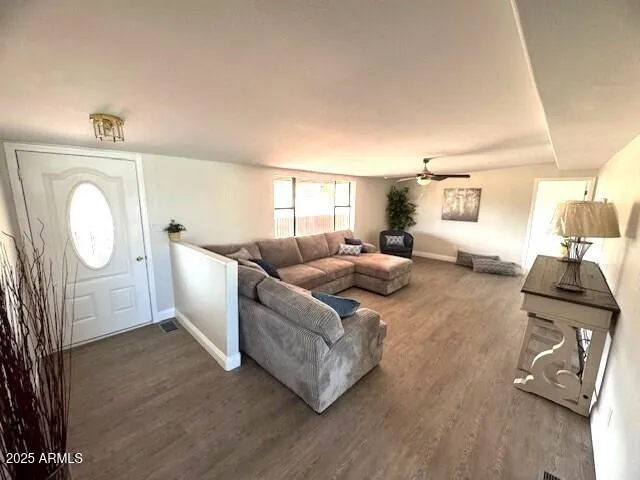 an empty room with wooden floor mirror and windows