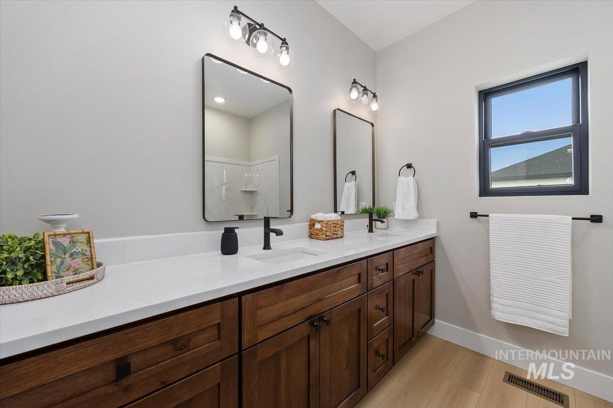 1201 Jade Drive Rupert, ID 83350 - Photo 17 of 27 Dual vanity with wood-finish cabinetry, white countertops, and matte black hardware