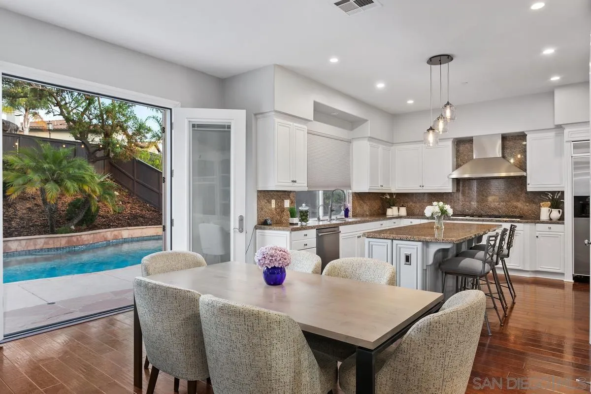 16309 Deer Ridge Road San Diego, CA 92127 - Photo 17 of 37 a kitchen with stainless steel appliances granite countertop a stove a refrigerator a kitchen island a table and chairs