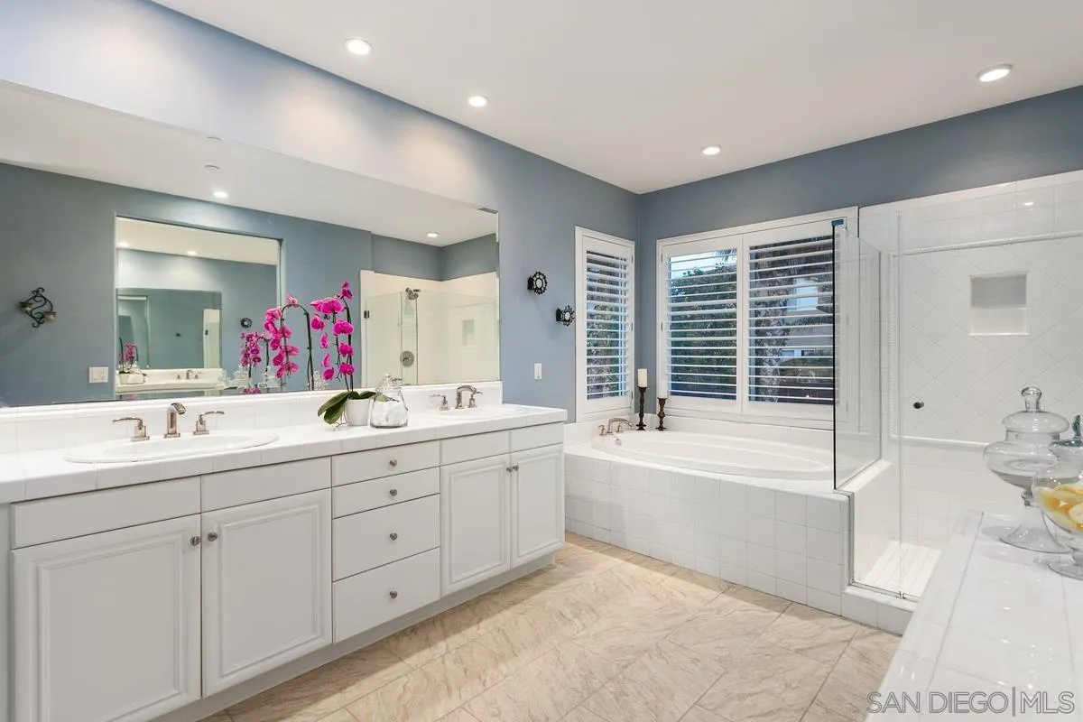 16309 Deer Ridge Road San Diego, CA 92127 - Photo 28 of 37 a bathroom with a tub a sink a mirror a shower and vanity