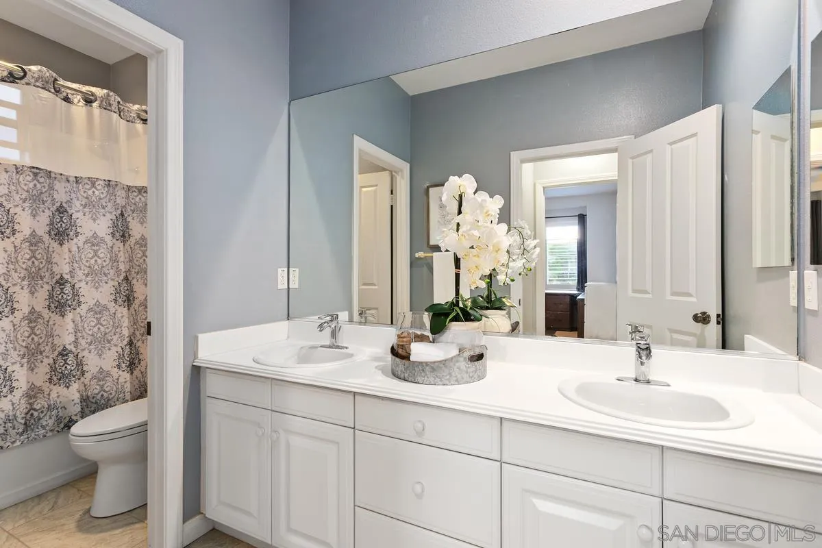 16309 Deer Ridge Road San Diego, CA 92127 - Photo 31 of 37 a bathroom with a double vanity sink toilet and a mirror