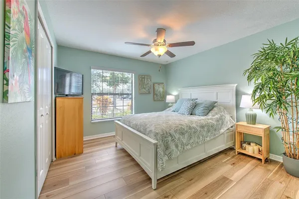 a bedroom with a bed wooden floor and window