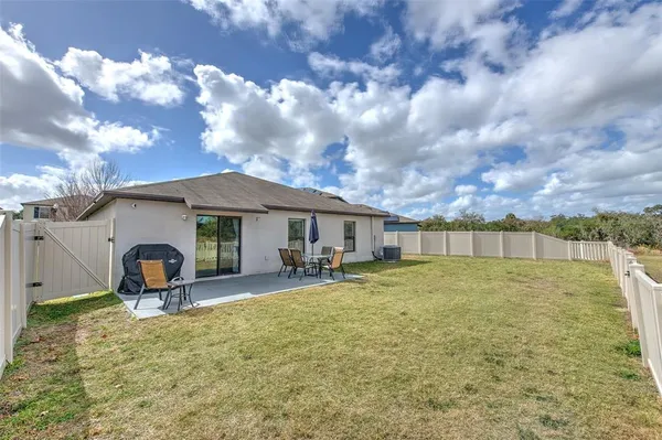 a backyard of a house with table and chairs